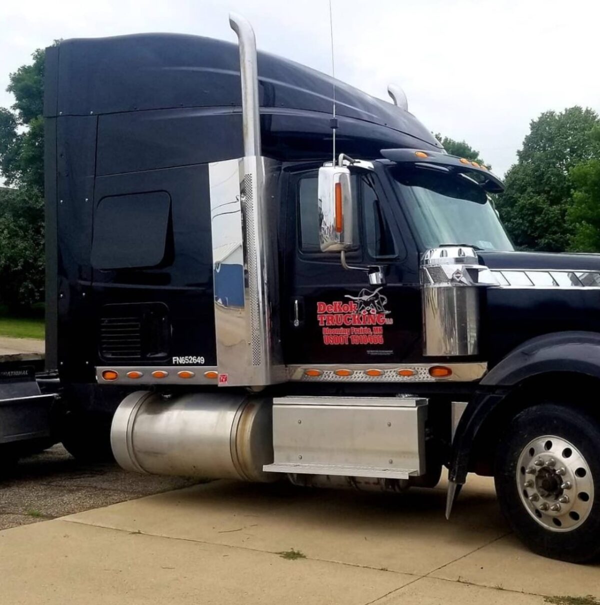 Big dark blue semi-truck with lots of chrome.